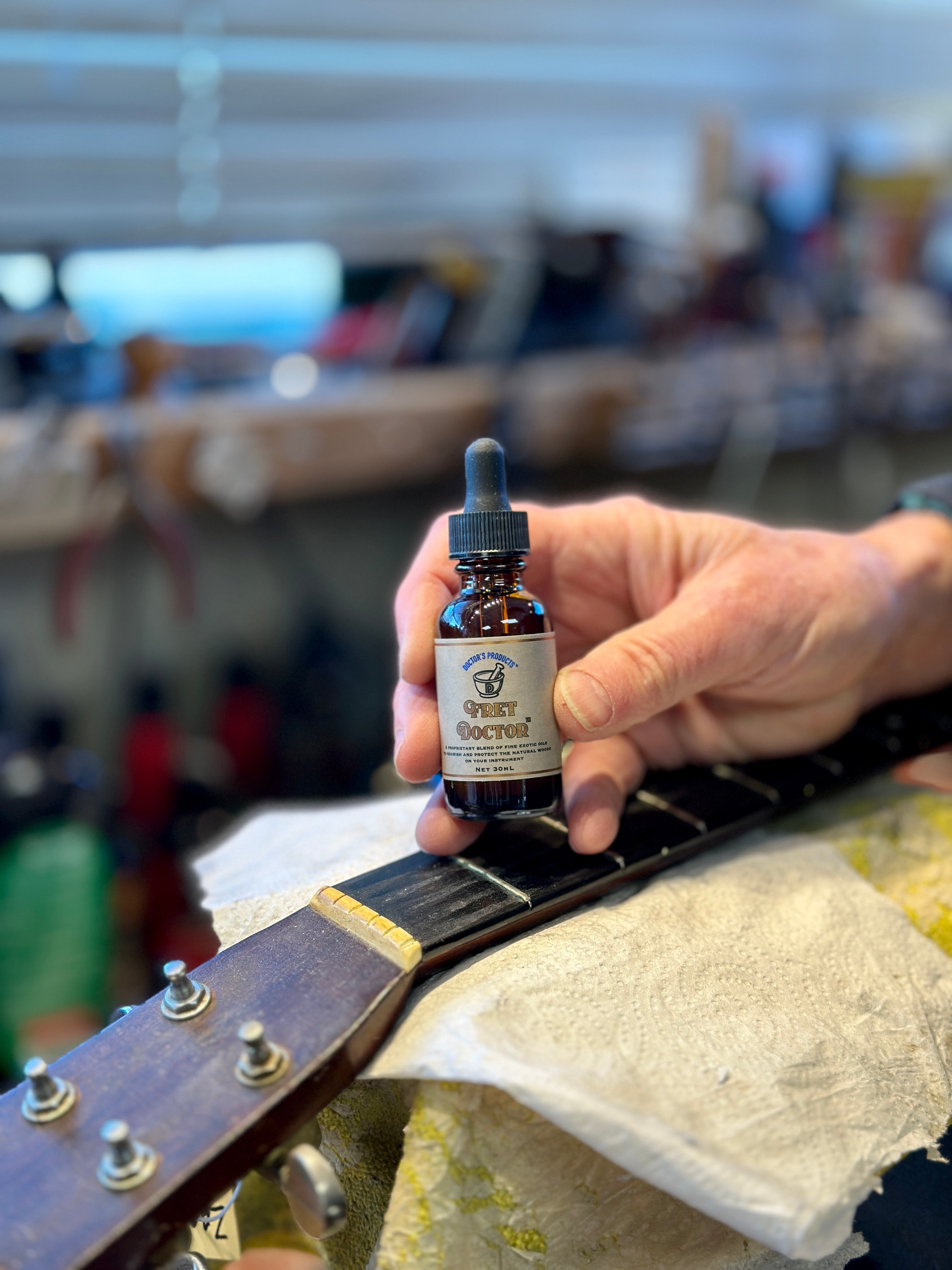 Fret Doctor 30 ml product shot satisfied luthier holding up bottle